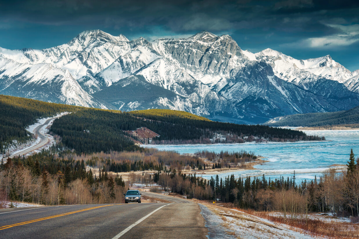 Scenery Of Road Trip On Highway With Rocky Mountains And Frozen
